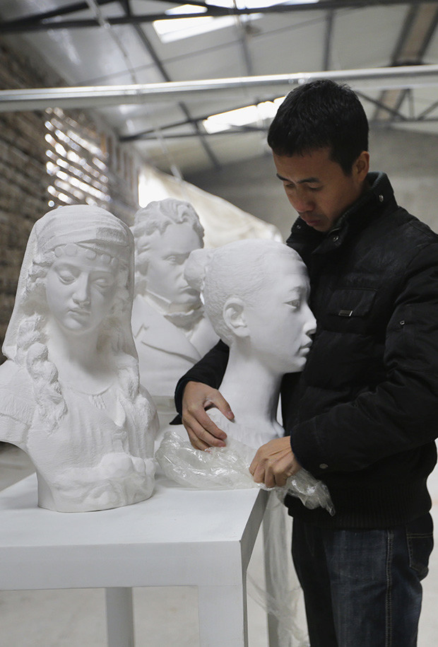 Chinese artist Li holds one of his paper sculptures at his studio on the outskirts of Beijing