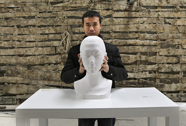 Chinese artist Li Hongbo shows his paper sculpture work, which is made of 6000 pieces of paper, on the outskirts of Beijing