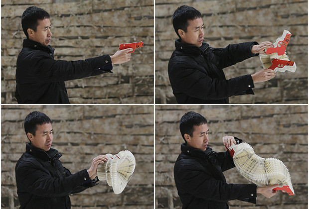 A combination picture shows Chinese artist Li Hongbo playing a paper sculpture of gun on outskirts of Beijing
